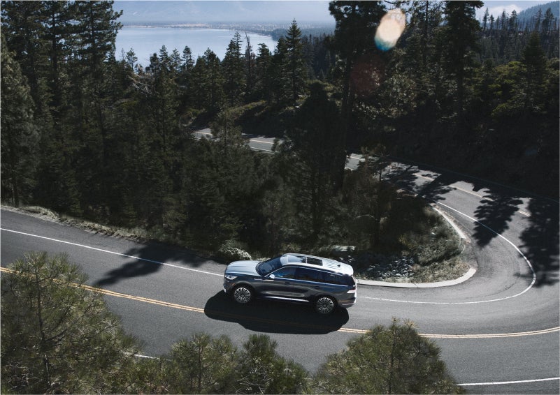 A 2023 Lincoln Aviator® SUV is being driven on a winding mountain road | Brinson Lincoln of Athens in Athens TX