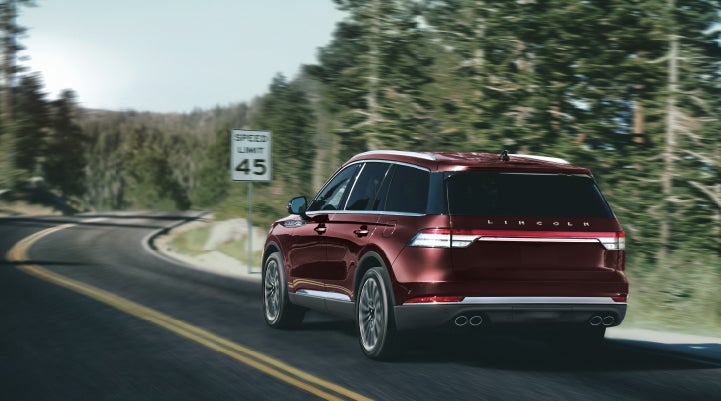 A 2024 Lincoln Aviator® SUV is being driven on a winding mountain road | Brinson Lincoln of Athens in Athens TX